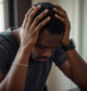 black-man-with-his-hands-on-his-head-while-his-hea